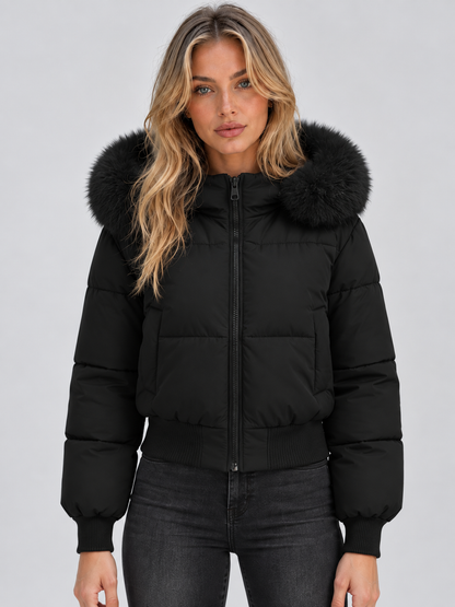 Frontansicht der kurzen schwarzen Steppjacke mit Fellkragen und Rippbündchen, getragen mit dunkler Jeans 1