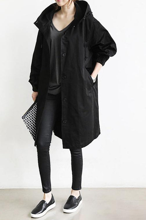 Schwarze Ausführung, getragen mit dunklem Shirt, Leggings, Slippern und gemusterter Clutch in der Hand 2