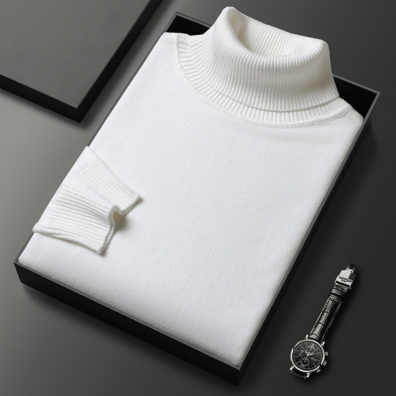 Weißer Rollkragenpullover gefaltet in einer schwarzen Box, daneben eine Armbanduhr mit Lederarmband; der Rippkragen und das Bündchen sind gut erkennbar. 6