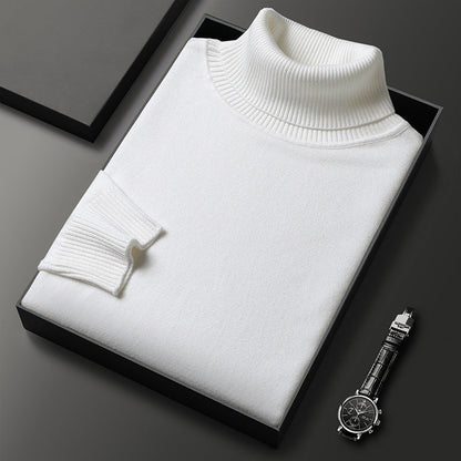 Weißer Rollkragenpullover gefaltet in einer schwarzen Box, daneben eine Armbanduhr mit Lederarmband; der Rippkragen und das Bündchen sind gut erkennbar. 6