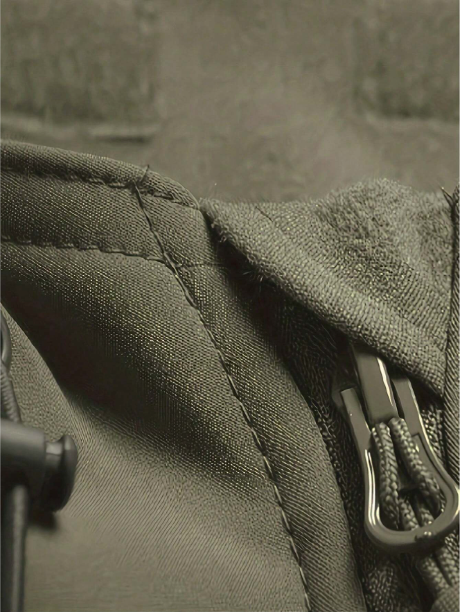 Detail des Kragens und Reißverschlusses der grünen Jacke mit Ziernaht, Fleecefutter und Kordelzug-Stopper.